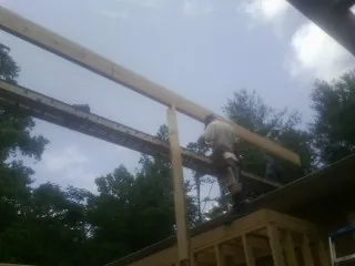 Carpenter setting a ridge beam over a new addition frame — Ice Dam Removal by Roofing Brothers in Forest Lake