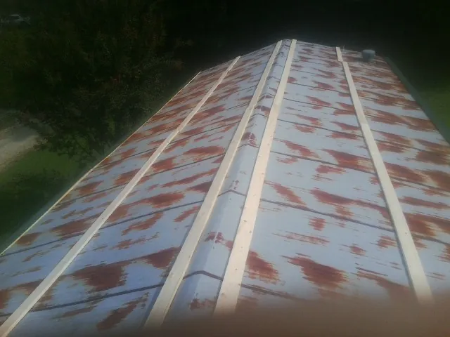 Rusted metal roof panels with new wood purlins before replacement — Storm Damage Roof Repair in Forest Lake by Roofing Brothers