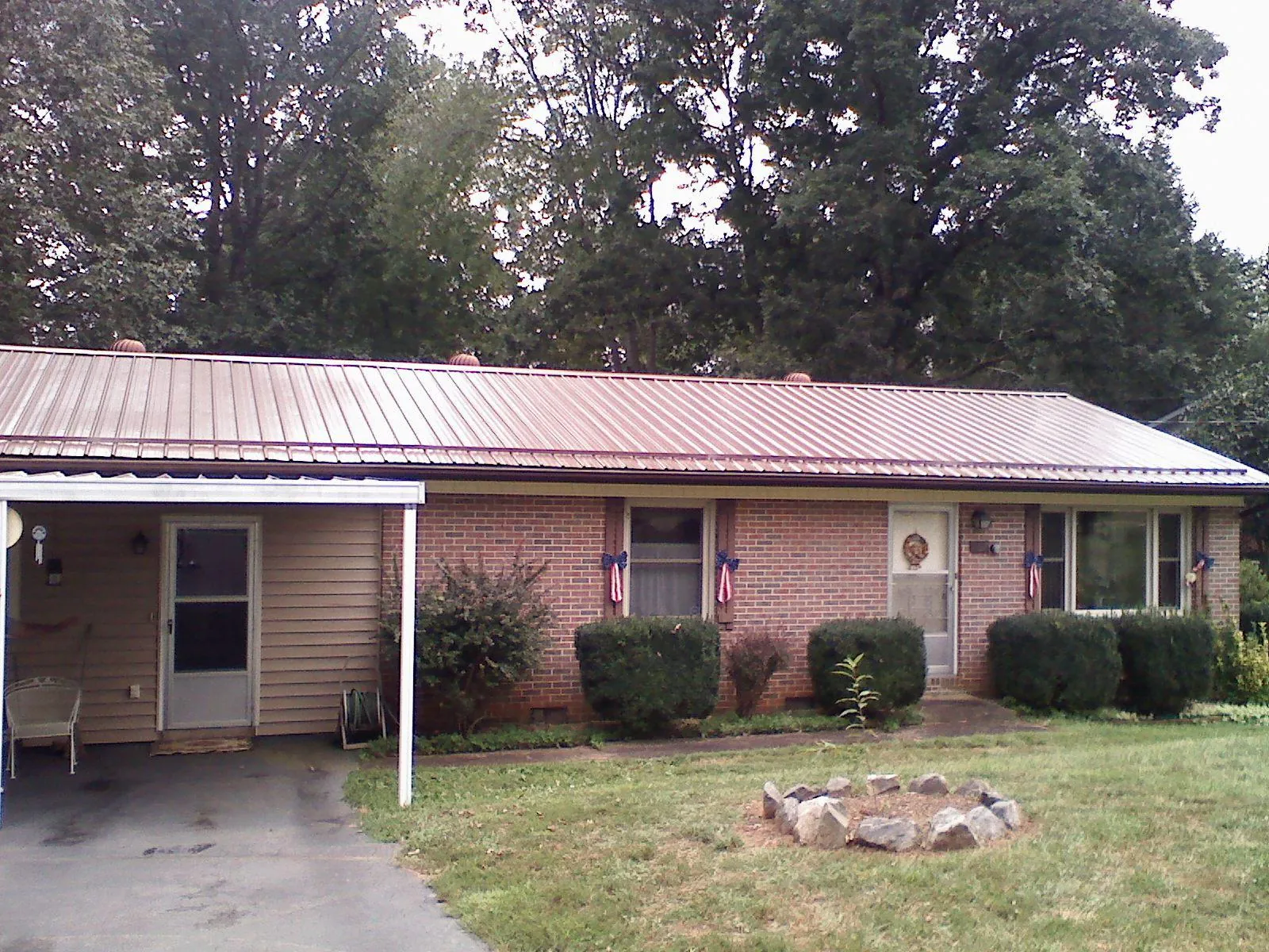 Bronze metal roof and carport on a brick ranch home — Roof Repair work by our crew in Forest Lake